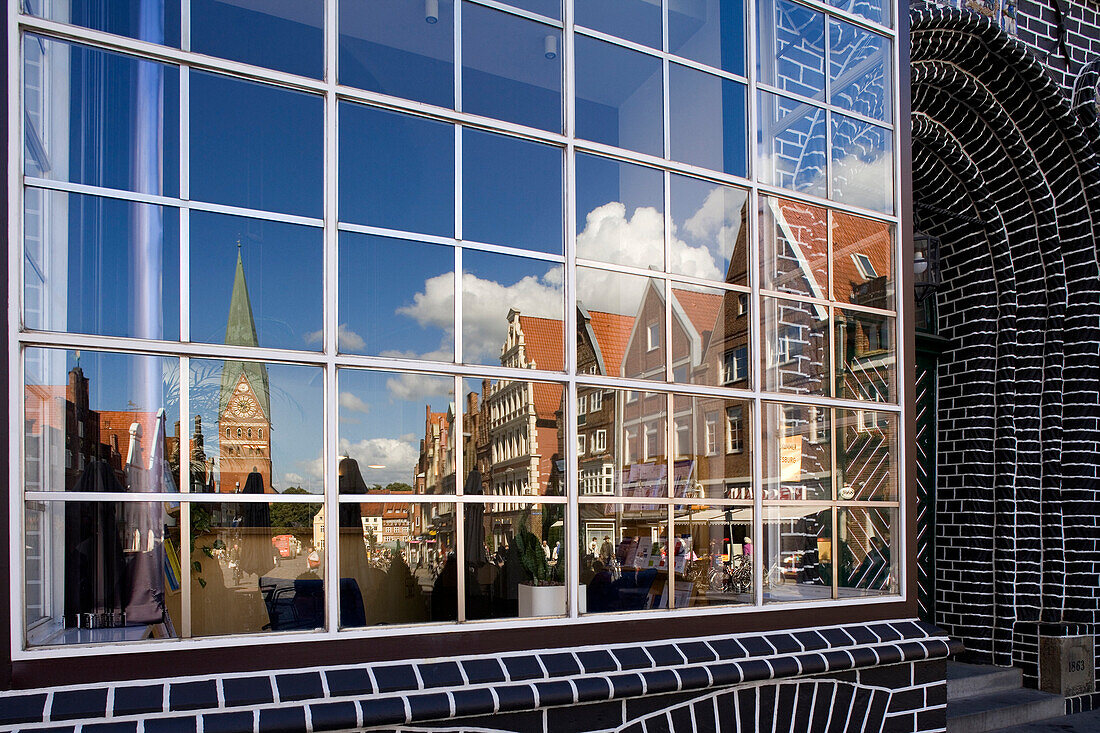 Reflection of St. John's Church and gabled houses in glass front, Luneburg, Lower Saxony, Germany