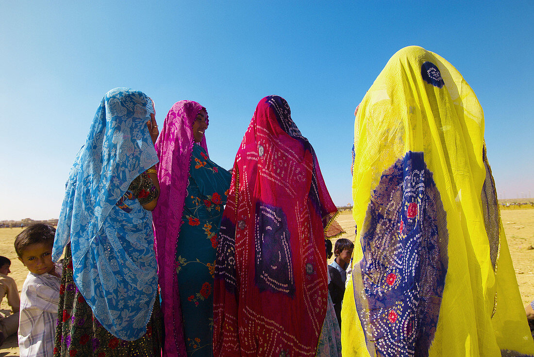 Women in saris watching performances at the Desert Festival, Jaisalmer, Rajasthan, India