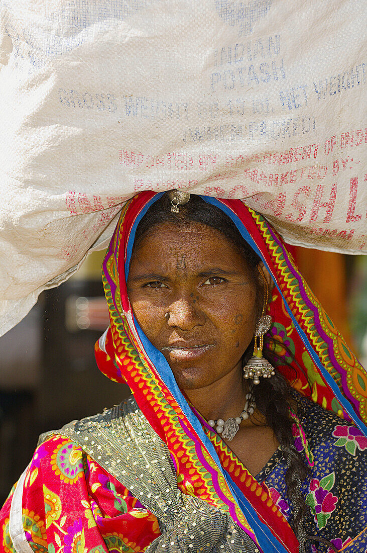 Woman carrying a load on her head, Jaisalmer, Rajasthan, India