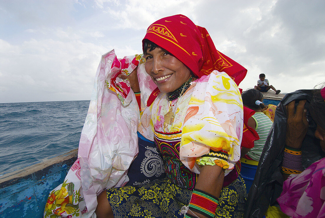 Kuna Indian women in native costume with Mola embrodery blouses leaving Corbisky Island in a dugout canoe, San Blas Islands (Kuna Yala), Caribbean Sea, Panama