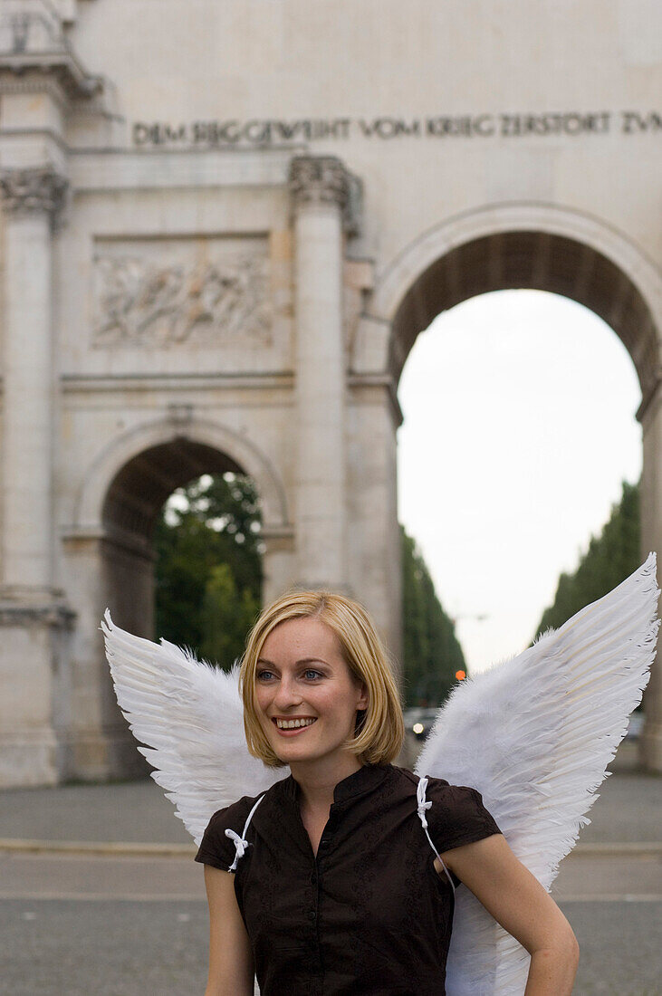 Angel, young woman with wings at the victory gate, Siegestor in Munich, Bavaria, Germany