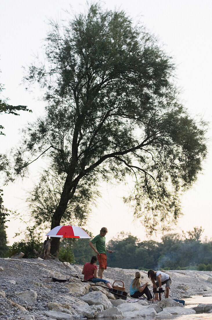 Group of young people grilling at river Isar, Munich, Bavaria, Germany