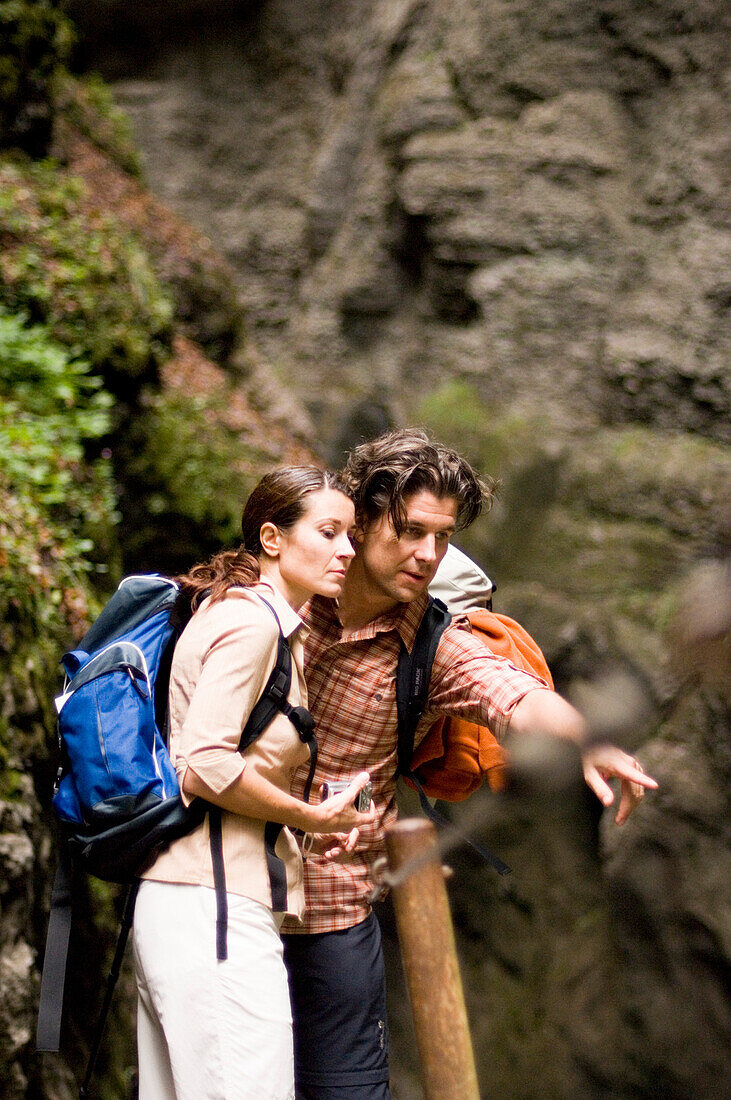 Couple hiking, man showing woman something interesting, Partnachklamm, Garmisch-Partenkirchen, Bavaria, Germany