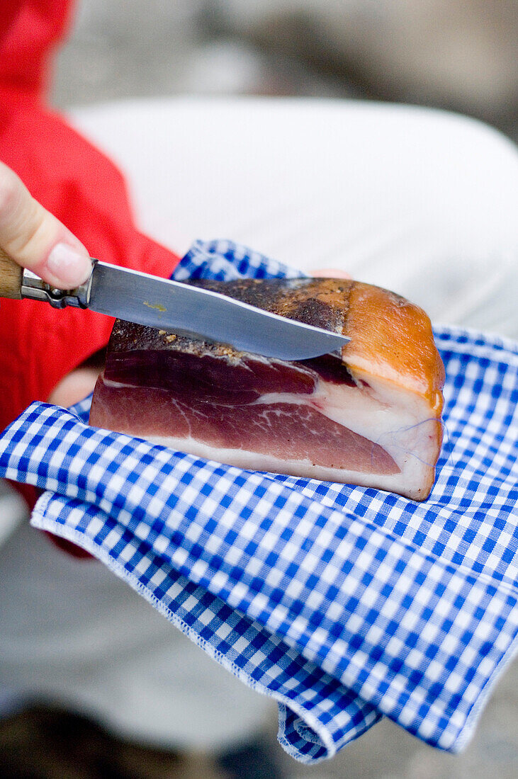 Person cutting ham