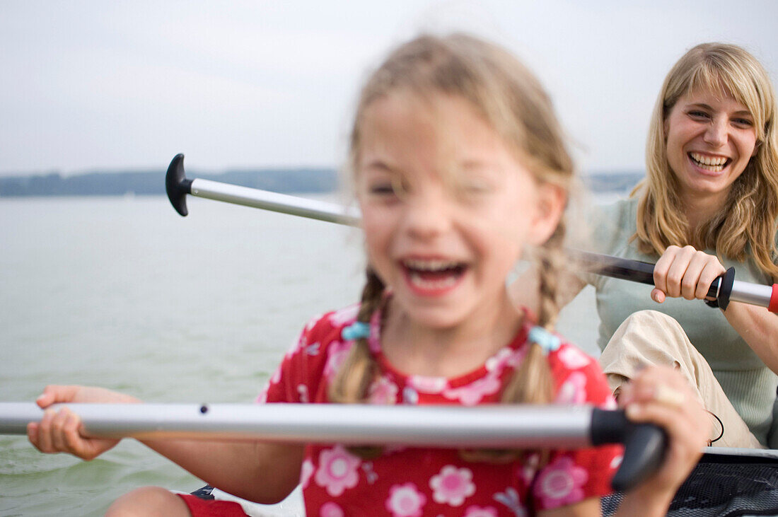 Mutter und Tochter paddeln auf dem Ammersee, Bayern, Deutschland