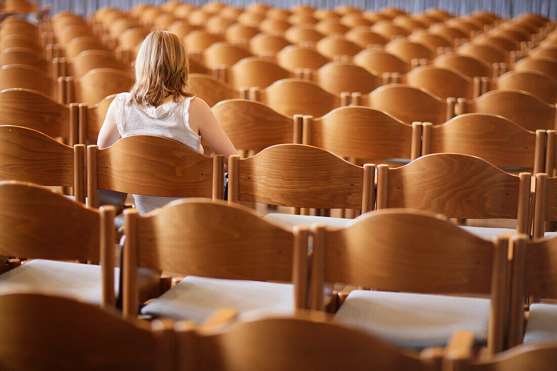 Student sitting in an empty lecture hall, University, Education