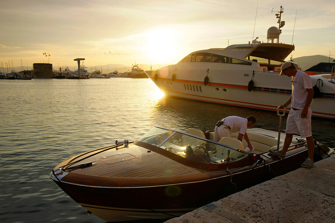 Two men getting into a motor boat at the yacht harbour, yacht, Promenade, St. Tropez, Cote d'Azur, Provence, France