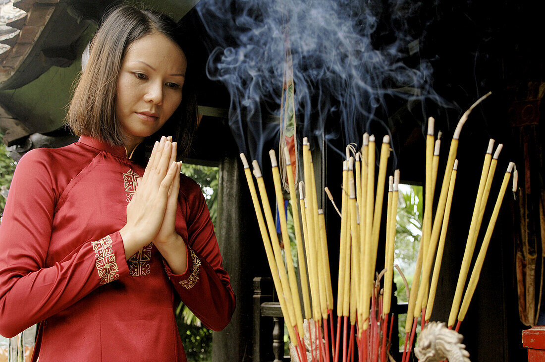 Vietnam. Hanoi. One pillar pagoda (Chua Mot Cot). Young Vietnamese girl praying.