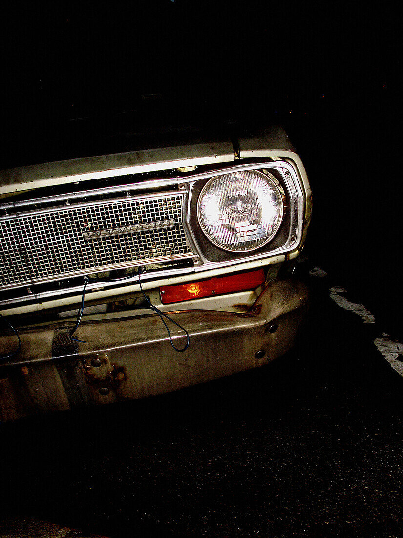 Single headlight of an old Plymouh automobile from the 1960s