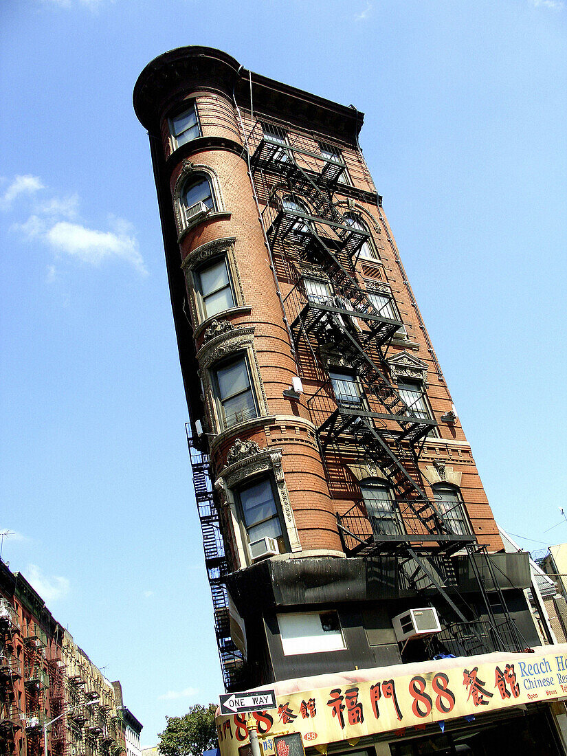 Cool, Flatiron-type-building in Chinatown, New York City. Shot against bright blue sky. USA