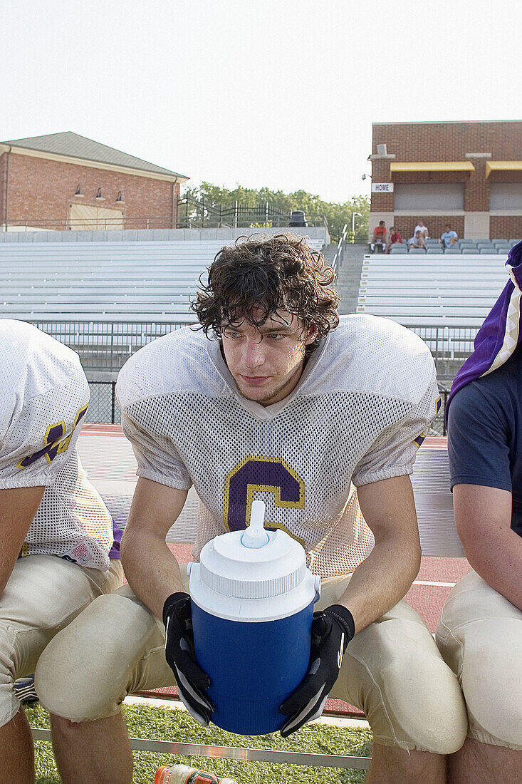 Football player takes a water break during practice.