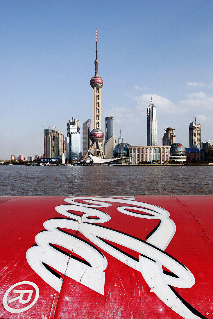 Coca Cola advertizing on the Bund with the Oriental Pearl TV tower and the skyline of Pudong business district in the background, Shanghai, China