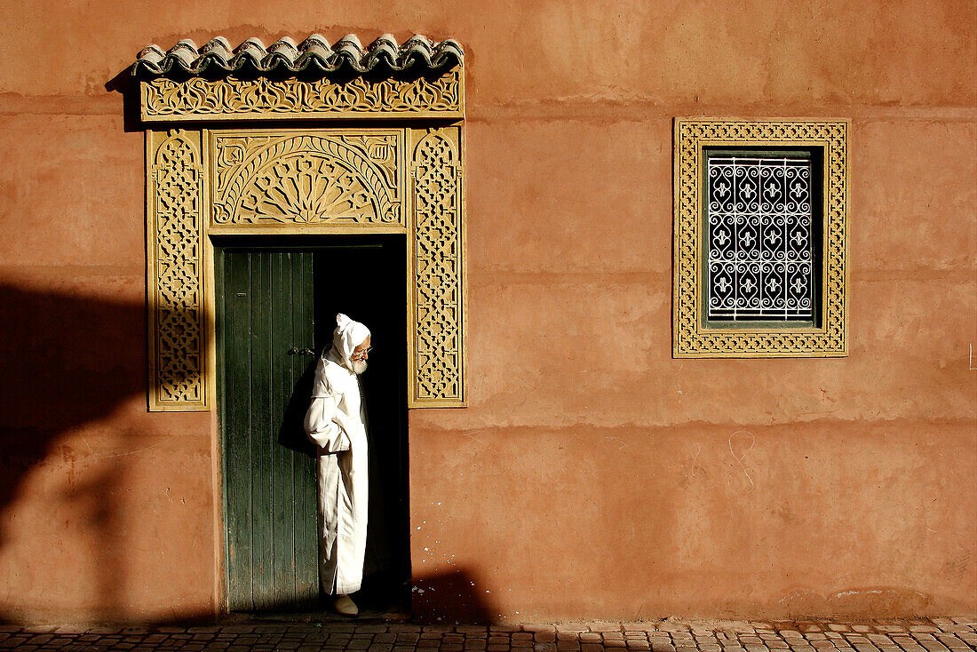 A man stand in front the entrance of a local house, Marrakech, Morocco