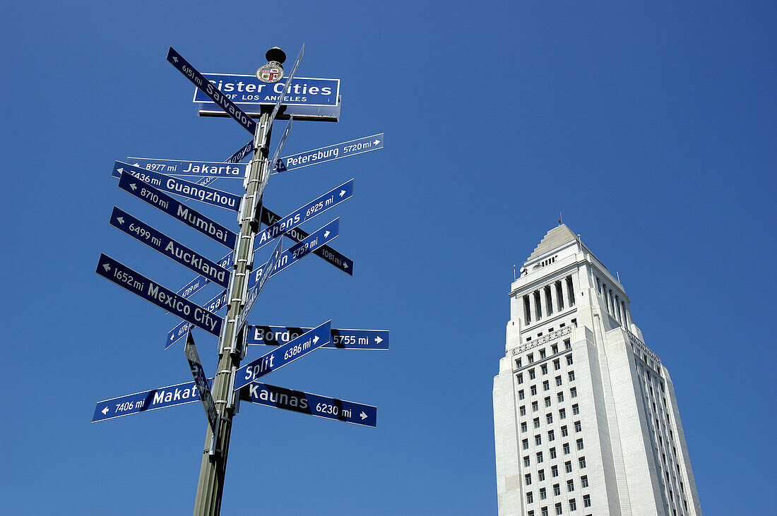 Mile signpost of Los Angeles sister cities around the world and Los Angeles City Hall building. California. USA.