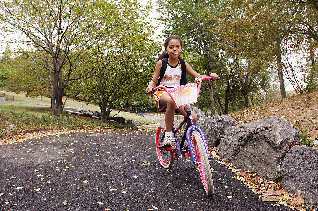 10-year-old biracial girl on a bicycle in Morningside Park, NYC. USA