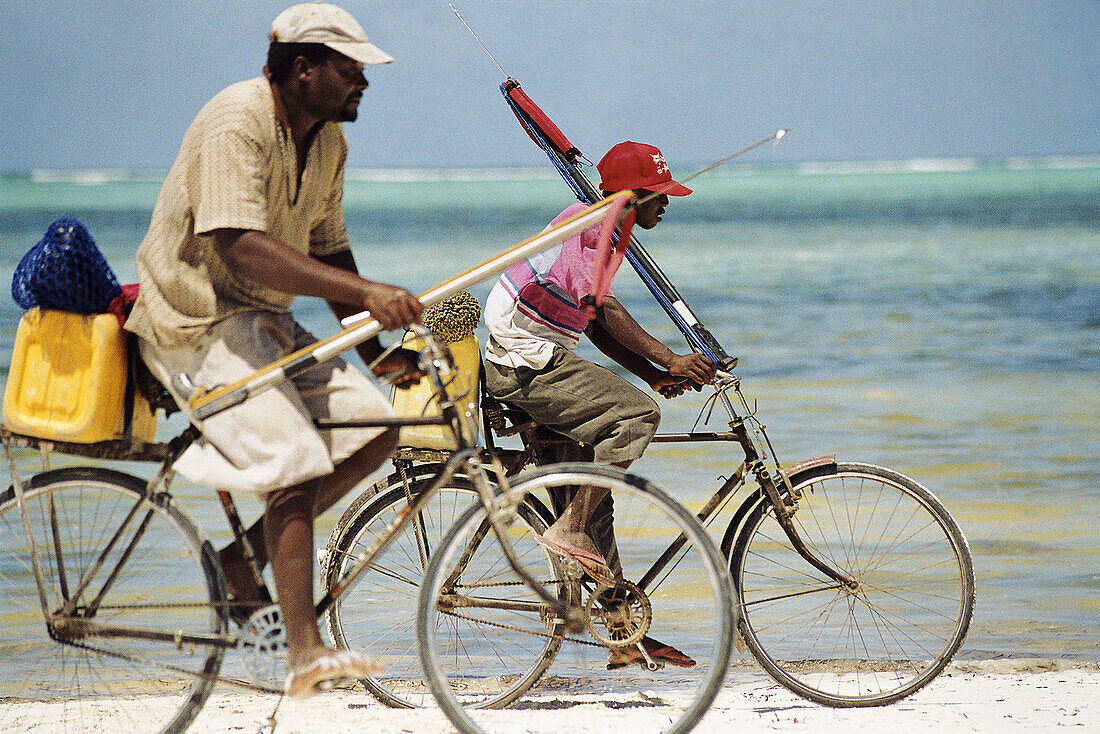 Fishermen going home by bike. Zanzibar, Tanzania