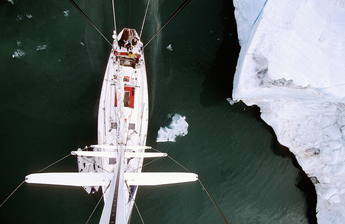View down from top of mast to deck of sailing boat passing iceberg, Kings Bay, Svalbard, Spitzbergen, Norway