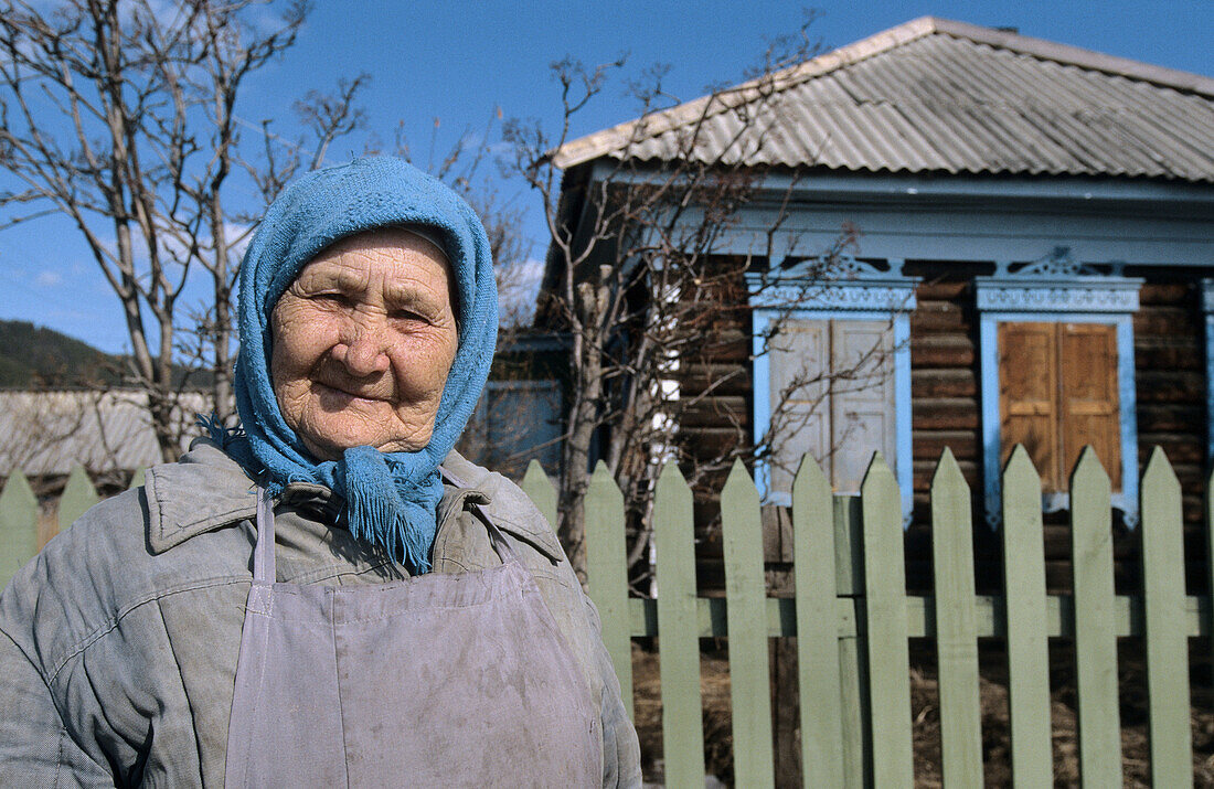 Woman in front of wooden house, Rougir village, Olhkon Island, Baikal lake, Siberia, Russia