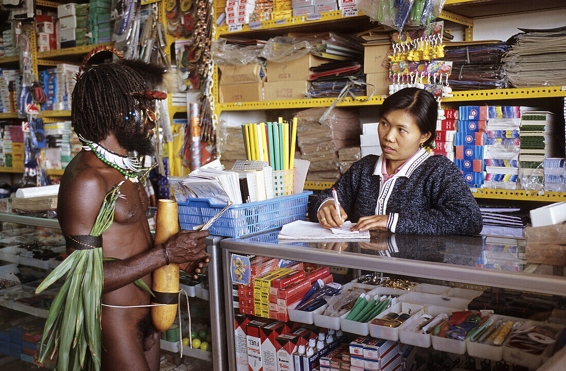 Dani hunter in an indonesian shop in Wamena, Baliem valley, Western Papuasia, Former Irian-Jaya, Indonesia