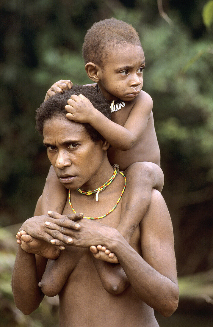 Koroway woman carrying her child on her shoulders, Western Papuasia, Former Irian-Jaya, Indonesia