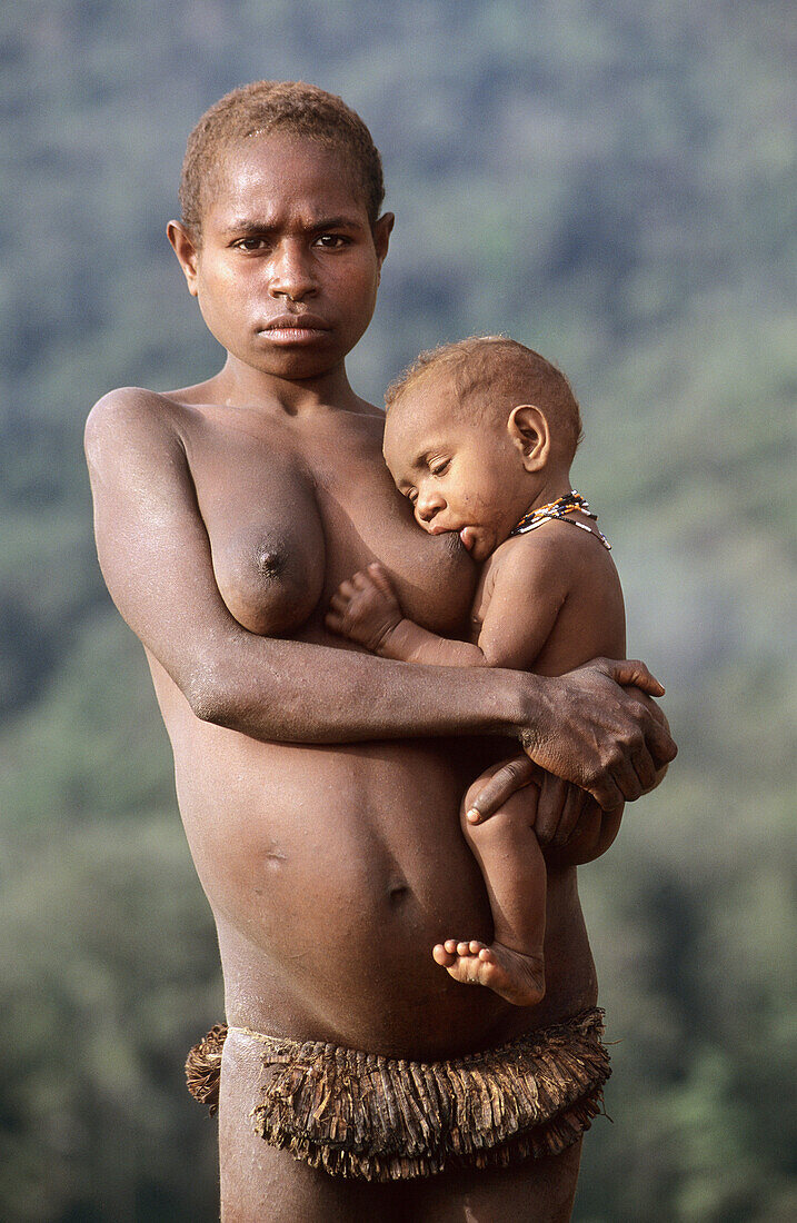 Young Yalis woman feeding baby, Western Papuasia, Former Irian-Jaya, Indonesia