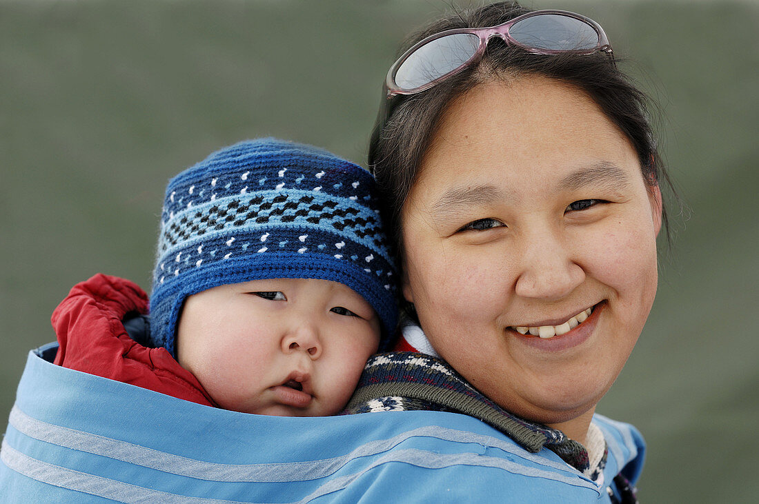 Woman Inuit carrying child in Nord West Territories, Canada