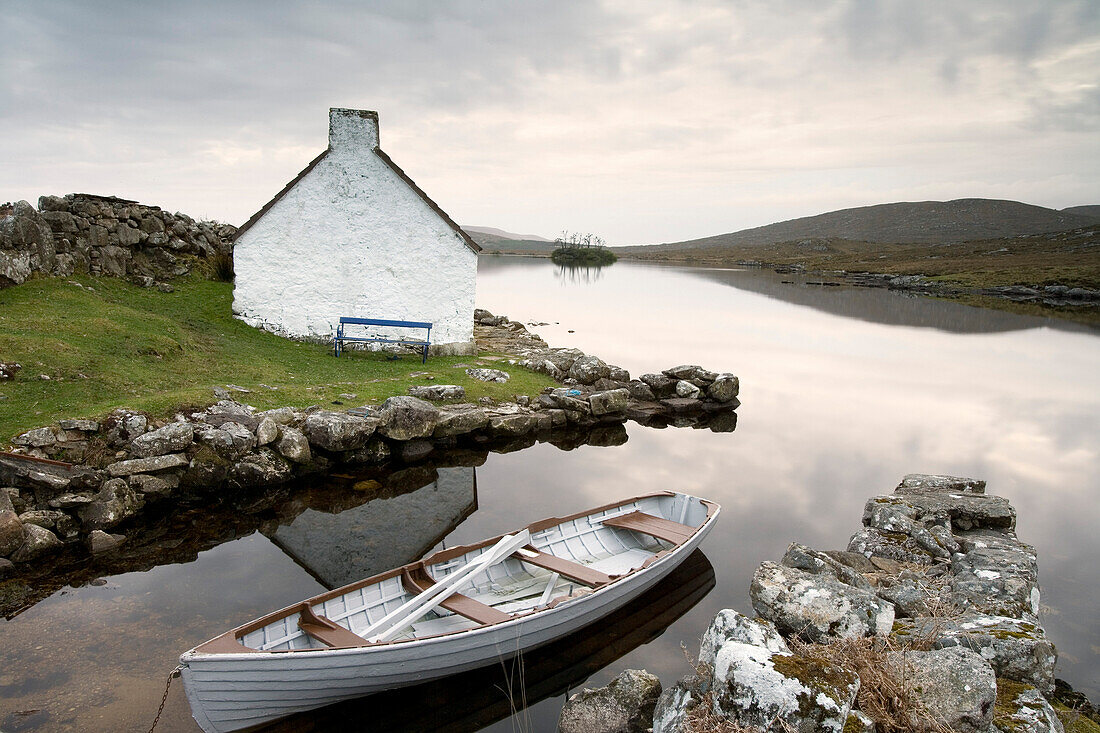 Cottage on the sea shore with rowing boat, Ireland, Europe