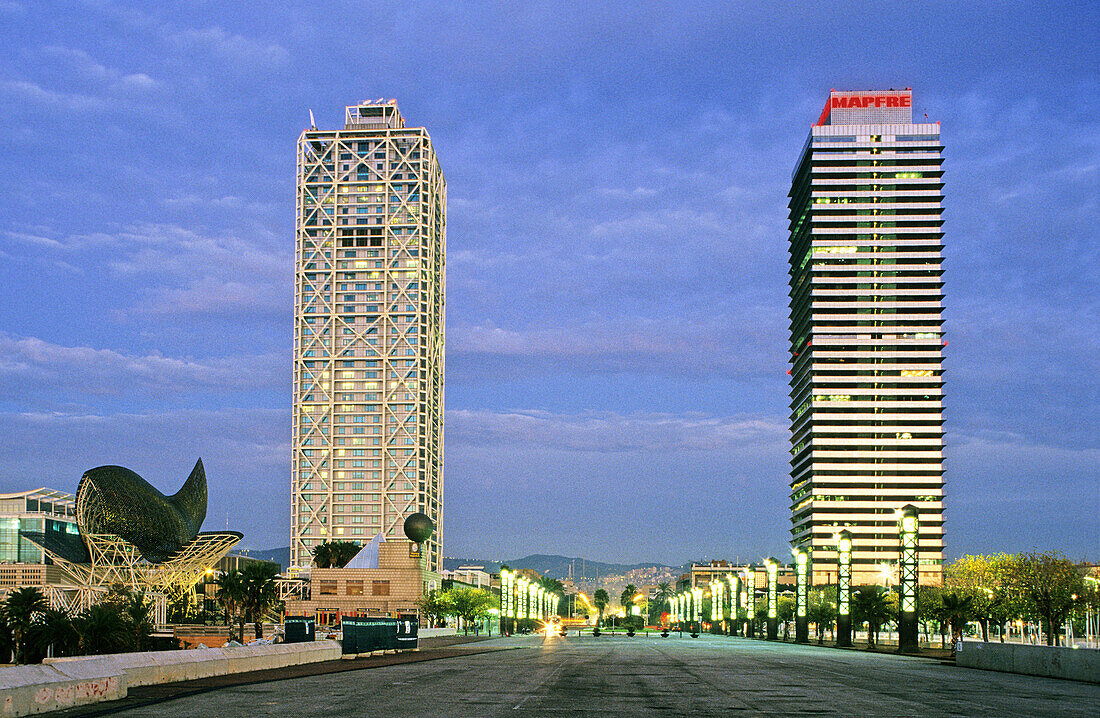 Hotel Arts (architects Bruce Graham and Frank O. Gehry), Mapfre Tower (architects Íñigo Ortiz and Enrique León) and Fish sculpture by Frank O. Gehry on the left at sunrise, Vila Olímpica. Barcelona. Catalonia, Spain