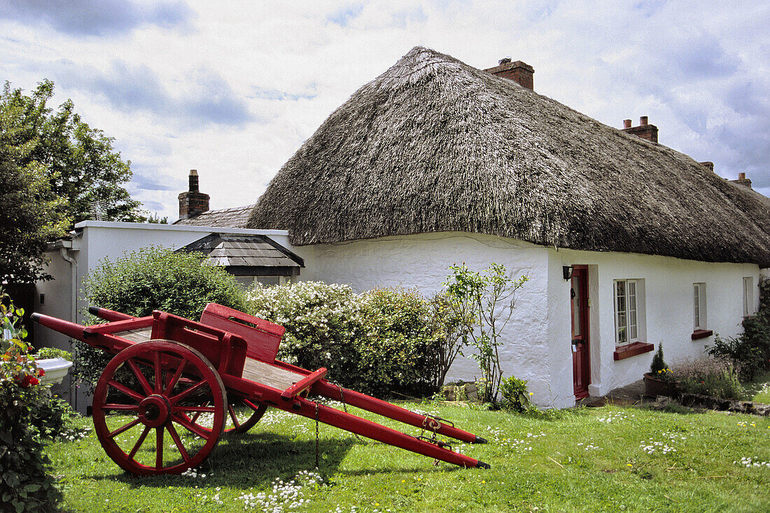Traditional thatched cottage and horse cart at fore in Adare. Co. Limerick, Ireland