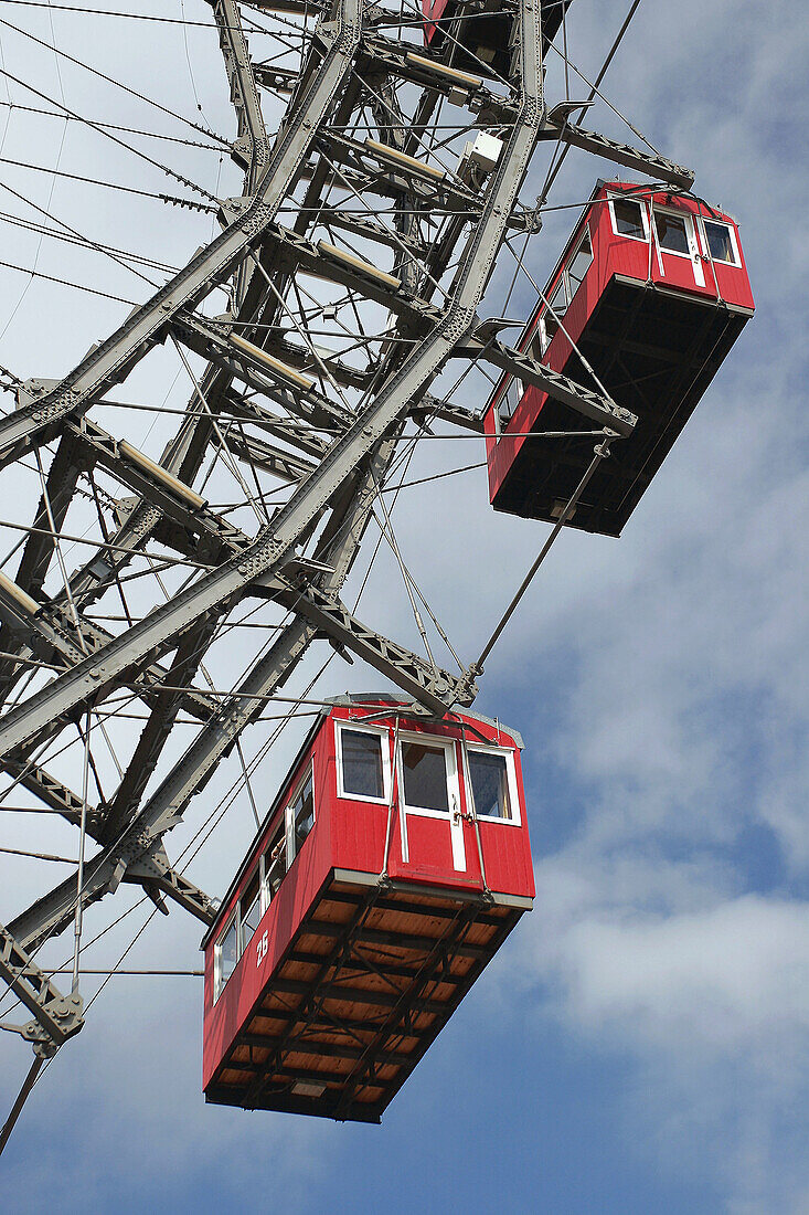 Bright red cabins of the giant ferris wheel located in the Prater funfair park in Vienna, Austria.