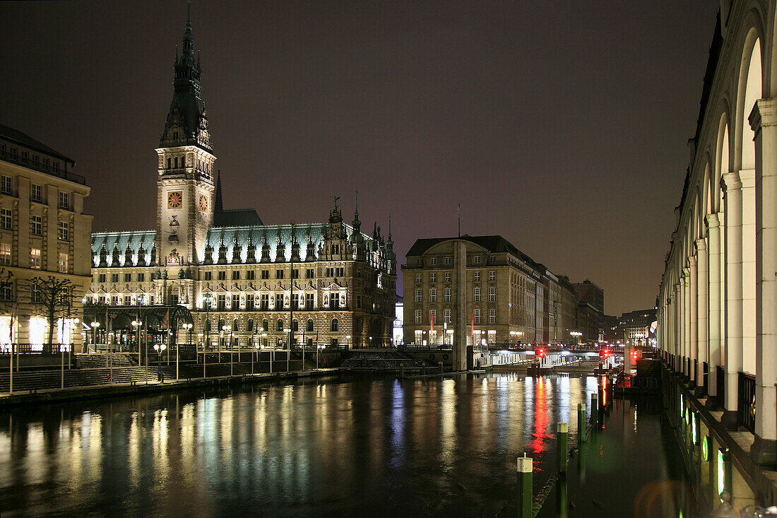 Hamburgs World War 1 Memorial, Rathaus, Alster Arkaden and the Alster River by night in Hamburg, Germany.