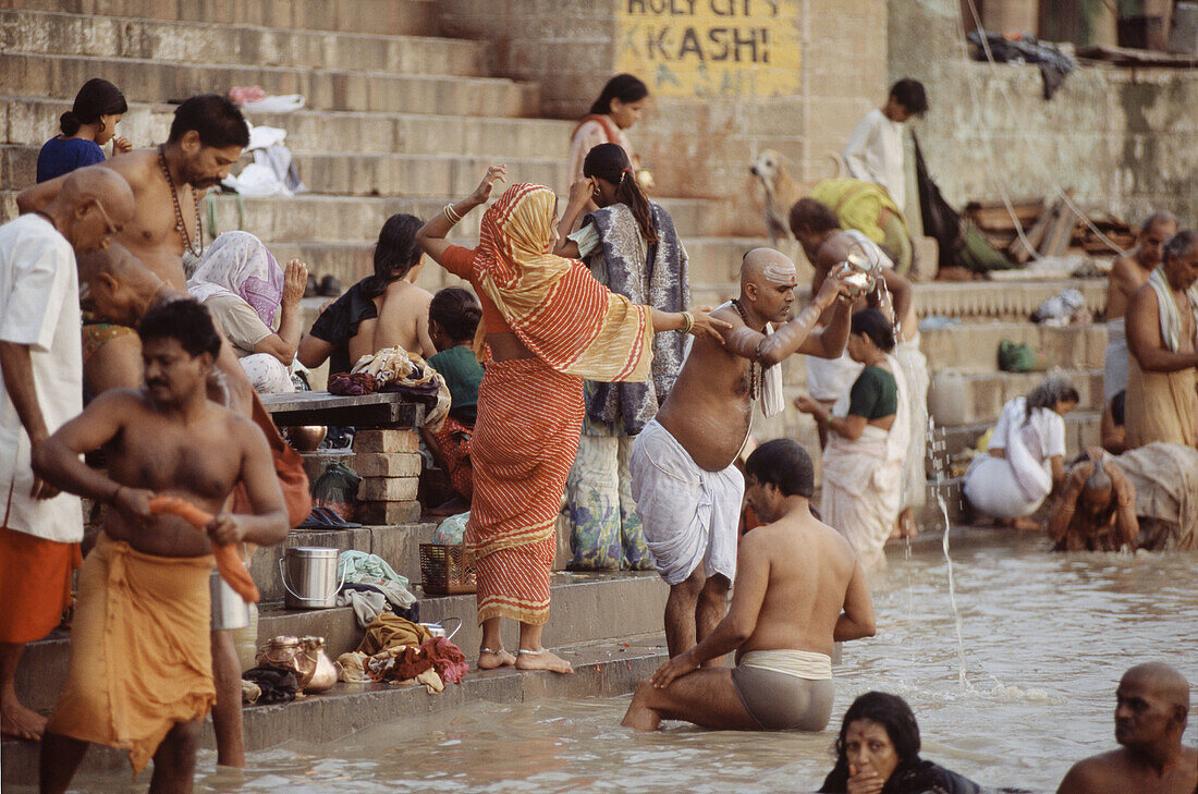 People praying at sunrise in the Kedar ghat on Ganges river, Varanasi. Uttar Pradesh, India (October, 2005)