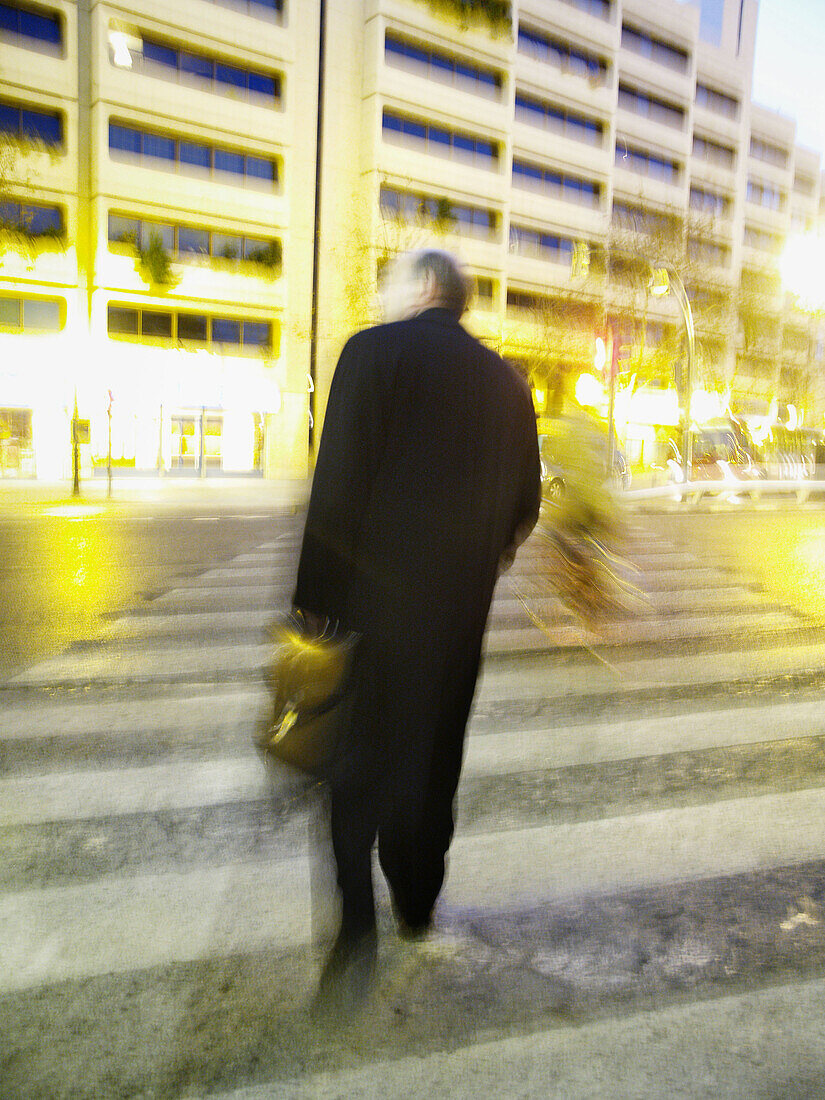 Businessman crossing the street in the evening.