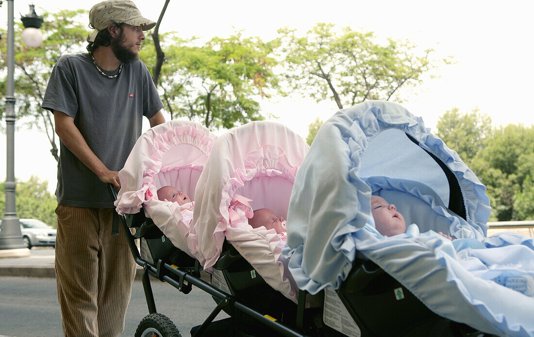 Aktivität, Aussen, Baby, Babys, Bruder, Brüder, Draussen, Drilling, Drillinge, Erwachsene, Erwachsener, Familie, Familien, Farbe, Geschwister, Kinderwagen, Lustig, Mann, Männer, Männlich, Mensch, Menschen, Schlendern, Schwester, Schwestern, Sonderbar, Spa