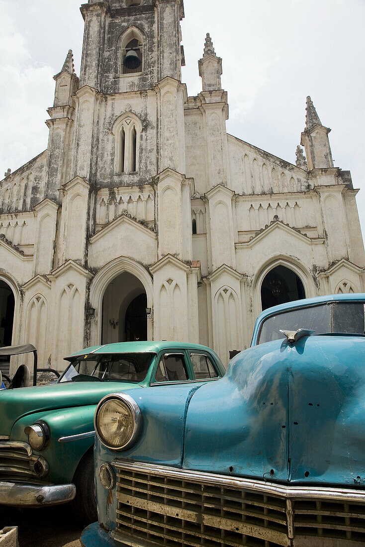 Iglesia del Santo Angel Custodio (Church of the Holy Guardian Angel). Old cars parked in front. Havana. Cuba.
