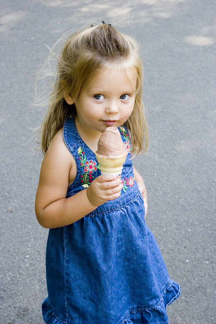 3-year old girl with an ice cream cone in Boston Public Garden. USA.