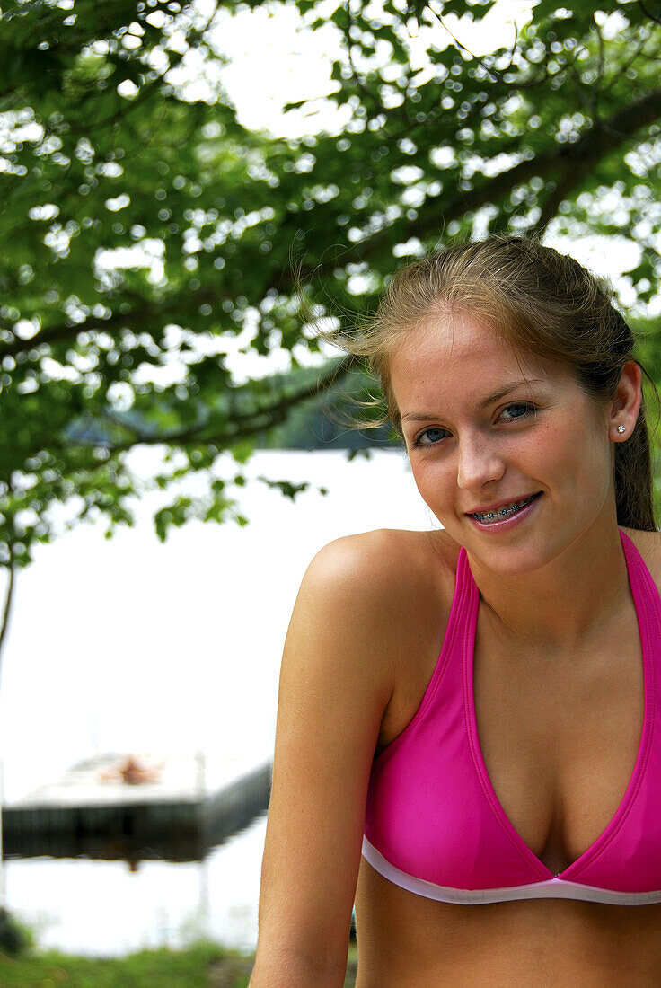 portrait of 18 yr old girl sitting on deck at cottage