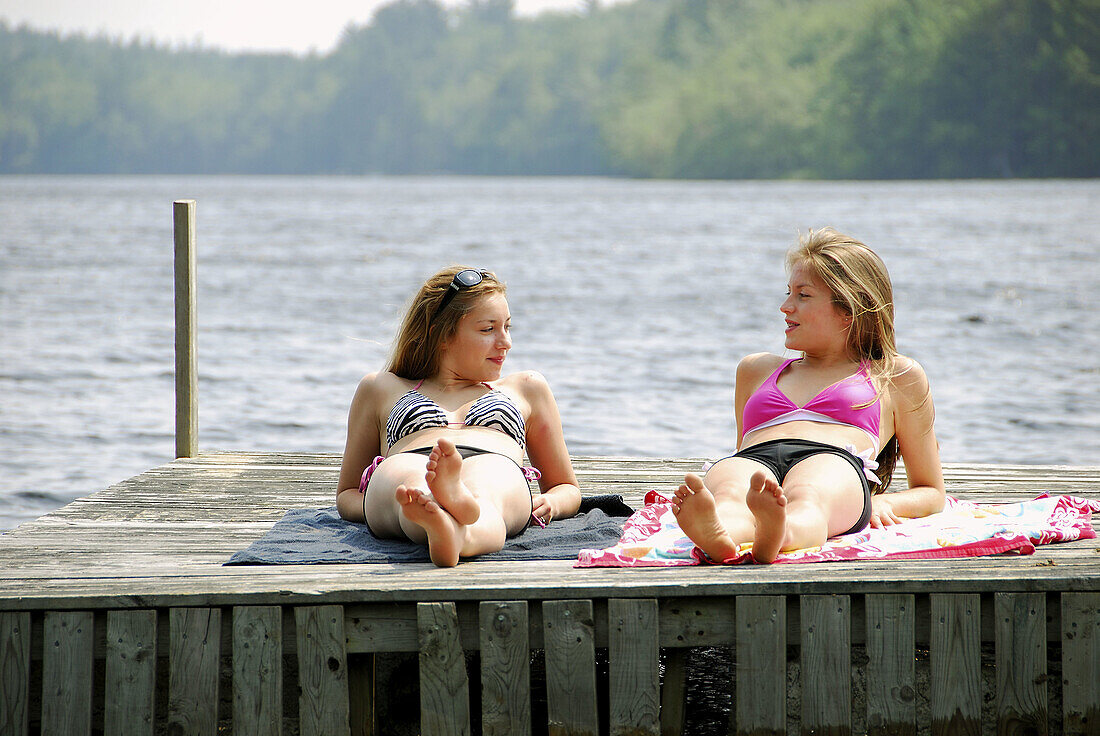 sisters 13 and 18, laying on dock talking and suntanning together