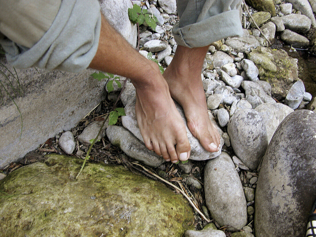 Feet resting next to the river. Espinama, Cantabria. Spain