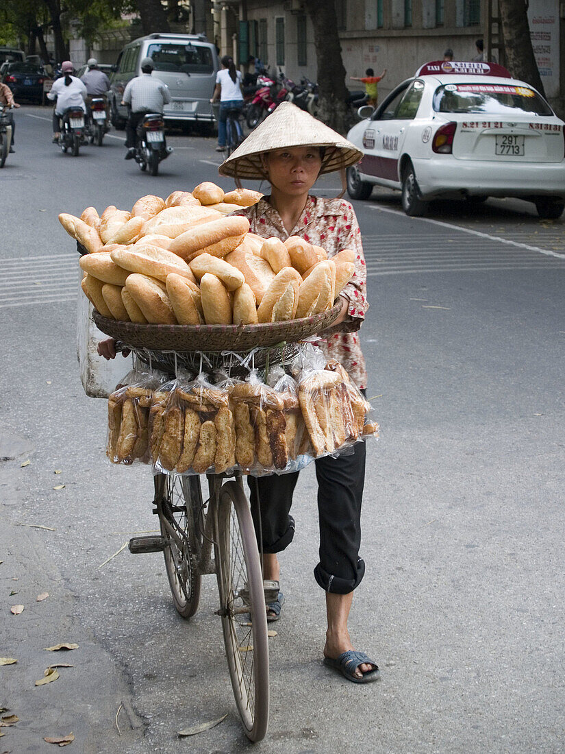 A bread vendor pedals her wares. Haiphong city, Vietnam (april 2006)