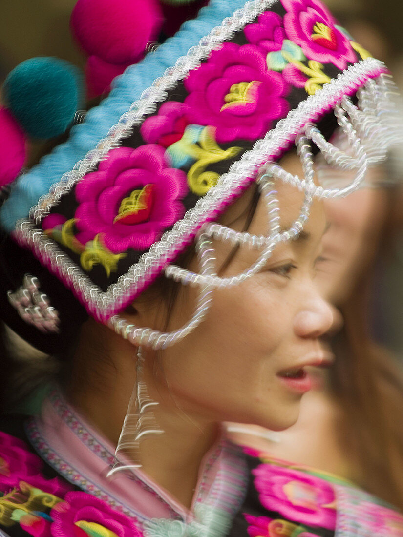 Hani gal moving through market in Kunming, China