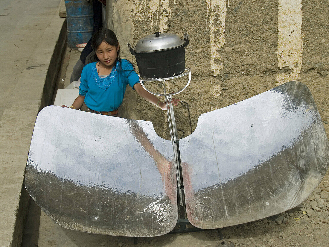 girl with a solar cooker, road to Zhongdian, China