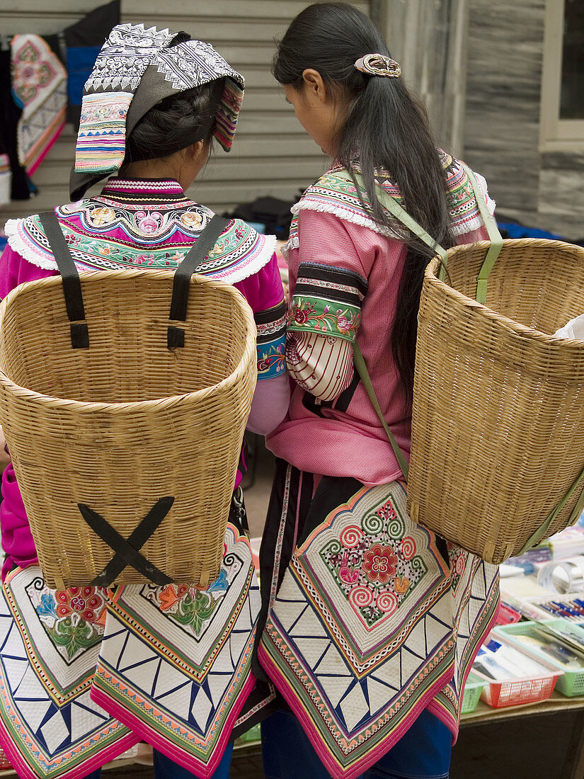 Yi women with their skirts, market, Yuanyang, China
