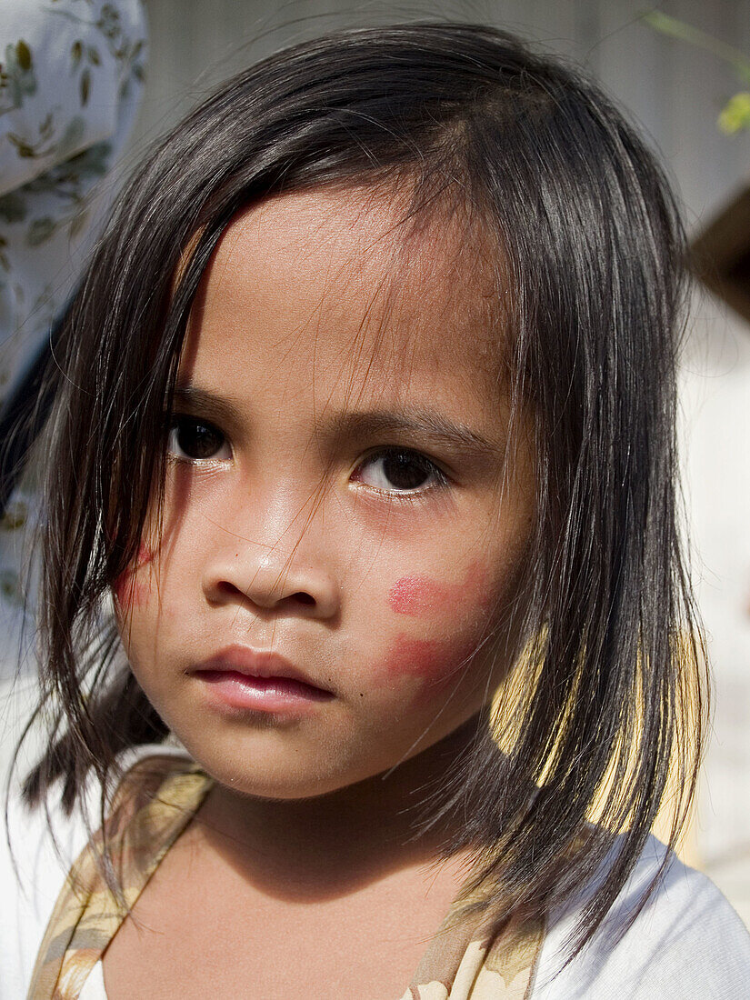 Young girl with dab of face paint at Ati Atihan Festival, Philippines