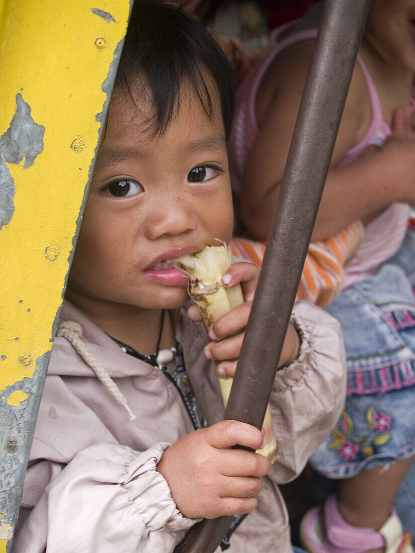 Filipina girl enjoying her sugar cane, Banaue, Philippines