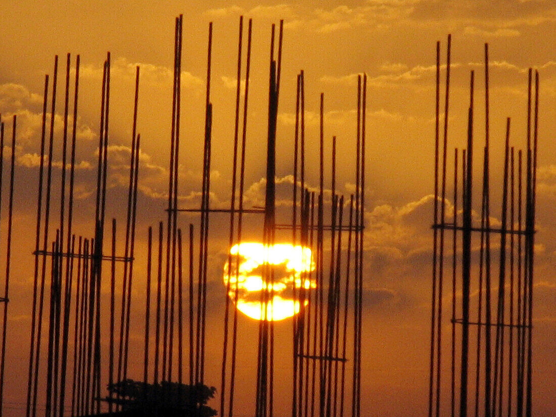 Sunrise behind the steel bar structure of a building construction work. Pune, Maharashtra, India.