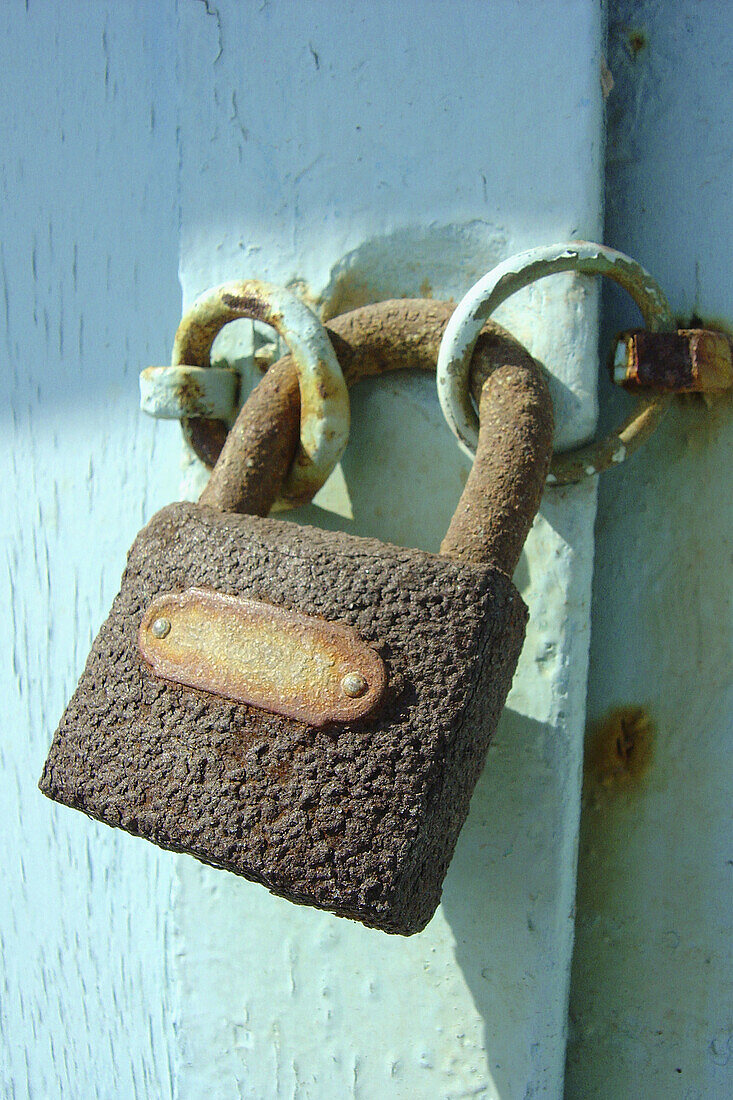 Rusted lock on turquoise door in Santorini, Greece