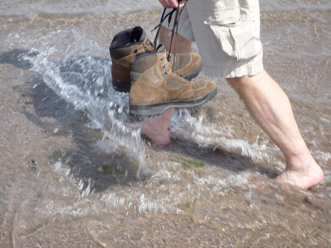 Barefoot Hiker on the Dingle Way walking along the beach, Ventry, Dingle Peninsula, County Kerry, Ireland