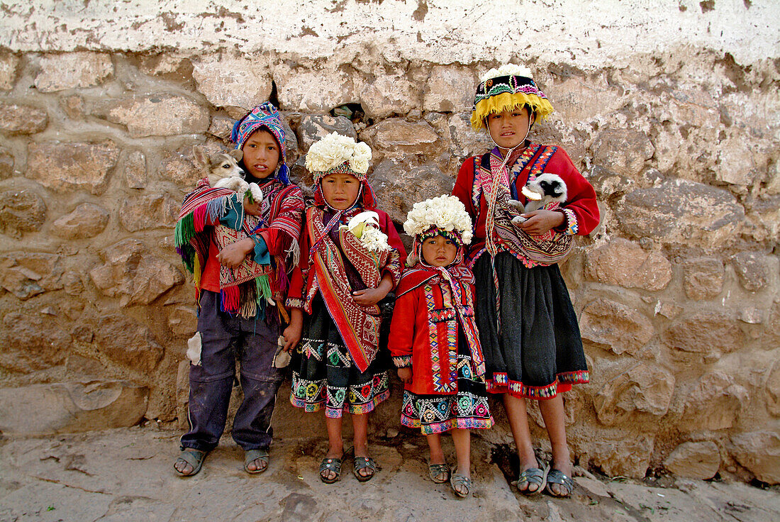 Inka Kinder mit Tieren an einer Hauswand in Pisac, Peru, Südamerika
