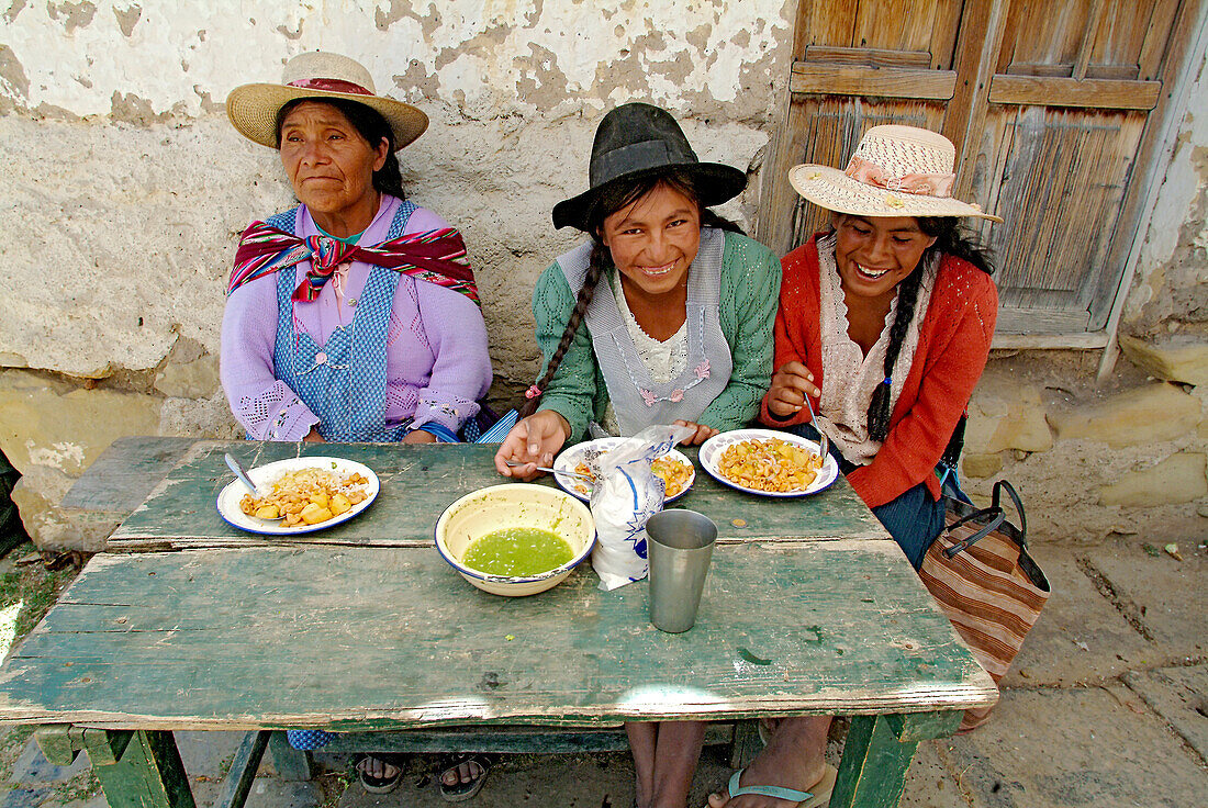Drei indigene Frauen beim Essen in Tarabuco, Bolivien, Südamerika